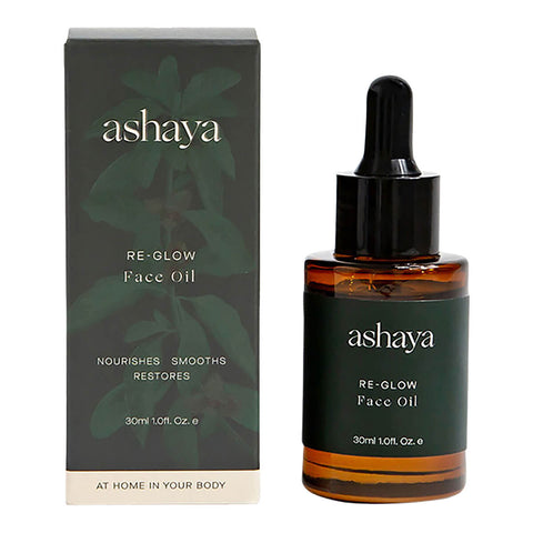 30ml dropper bottle of ashaya Re-Glow Face Oil next to its box, a formula designed to support the skin during the perimenopausal and menopausal years. This nutrient-rich botanical oil is infused with precious ingredients to help address the visible signs of aging, dark spots, dryness, and inflammation. Gently scented to soothe you throughout perimenopause. Suitable for all skin types.