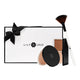 Lily Lolo Luminous Glow Collection makeup gift set including Pressed Finishing Powder, Sculpt & Gow Contour Duo, and Small Fan Brush. Packaged in a black and white gift box with a black bow.