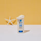 20g tube of Natural Zinc Stick SPF 50+, a clear, hydrating, vegan formula that provides UVA and UVB broad-spectrum protection from the sun while also being 4 hours water-resistant, styled with seashells against a yellow background. Packaged in a cream tube with minimal blue and black text on the label.