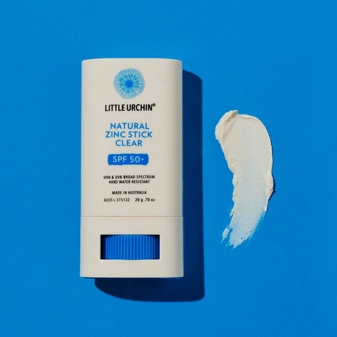 Swatch of Natural Zinc Stick SPF 50+, a clear, hydrating, vegan formula that provides UVA and UVB broad-spectrum protection from the sun while also being 4 hours water-resistant, next to its 20g tube. Packaged in a cream tube with minimal blue and black text on the label.