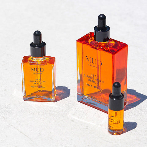 100ml, 30ml, and 5ml glass dropper bottles of Mud Organics Sea Buckthorn Serum, a hydrating and nourishing formula that improves the aging process, repairs sun damaged skin, and helps diminish hyperpigmentation.