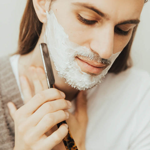 Man shaving with Sodashi Clean Skin Cleanser & Shaving Emulsion, a luxurious dual-action cream that deep cleanses and acts as a gentle shaving emulsion, softening stubble and preparing the skin for a comfortable shave.