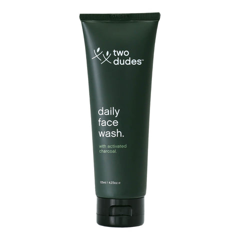 125ml bottle of Two Dudes Daily Face Wash containing activated charcoal that unclogs pores, removes dead skin, and regulates pH. Formulated for daily use and suitable for all skin types. Packaged in a dark green tube with minimal white text.