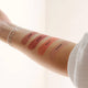 Winki Zinc's Tinted Lip Zinc shades (Rose, Berry, Peach, Almond) swatched on an arm. Tinted Lip Zinc is a mineral-based lip balm designed to heal and protect your lips from the sun while adding a hint of natural colour.