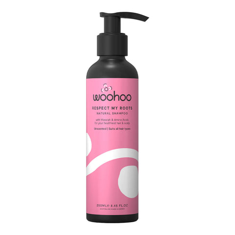 250ml pump bottle of Woohoo Respect My Roots Natural Shampoo, a gentle cleansing formula that hydrates, nourishes, and protects your hair and scalp, improving strength, smoothness, and shine. Packaged in a black recyclable aluminium bottle with a pink label and pump.